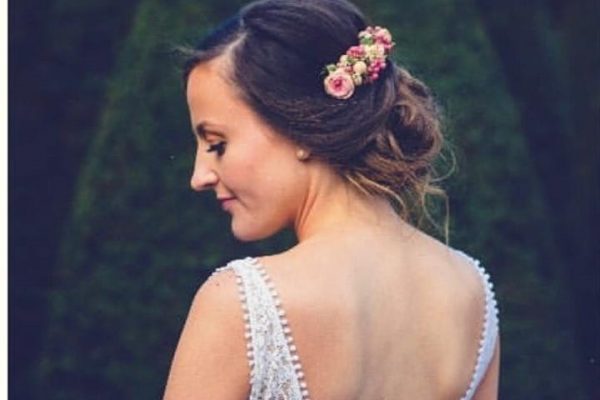 Haarspeld met verse bloemen uit het bruidsboeket voor een huwelijkskapsel