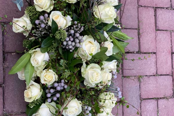 Groot kiststuk van witte rozen en herfstbessen FRM rouwwerk
