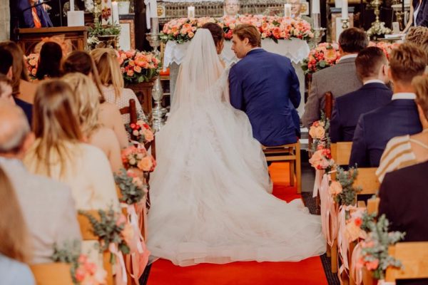 Bruidskoppel in met bloemen gedecoreerde kerk FRM